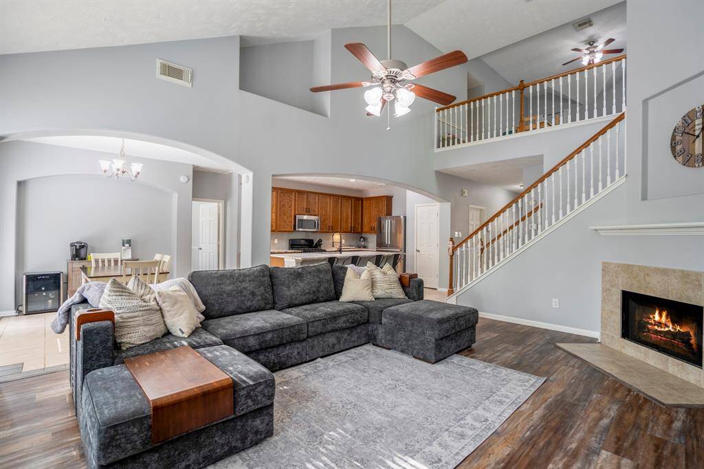 From this angle near the back windows, you’ll appreciate the grand two-story vaulted ceilings, recessed architectural details, and large arched openings that connect the living room to the breakfast area and kitchen—creating an open, elegant flow throughout the heart of the home.