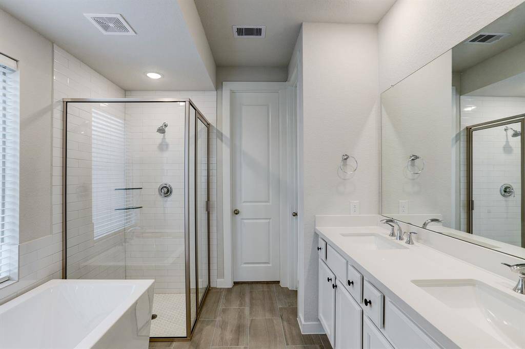 Primary ensuite bath features double sinks, quartz counters, water closet, separate soaking tub and shower, and walk-in closet.