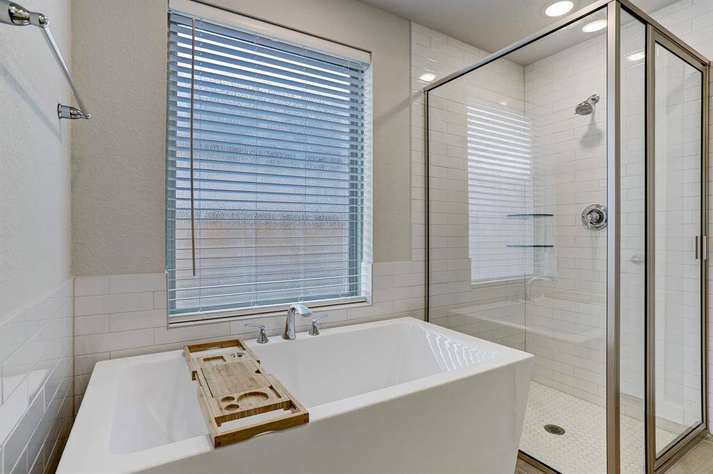 The primary bath features a separate soaking tub and shower with subway tile surround.