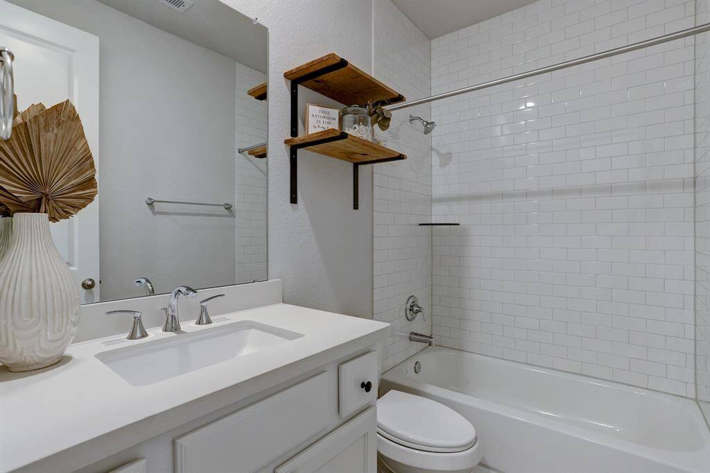 The 1st-floor secondary bath features a tub/shower combo with subway tile surround.