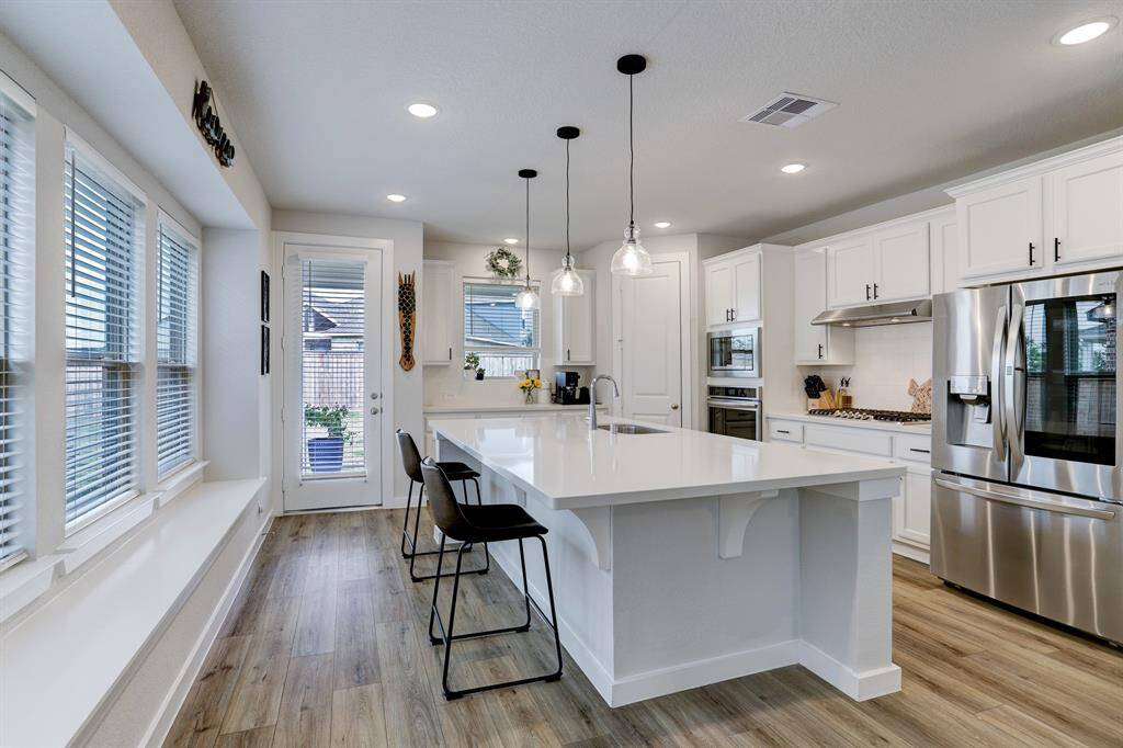 The fantastic sized kitchen features a coffee bar area, walk-in pantry, and door access to the covered patio and back yard.