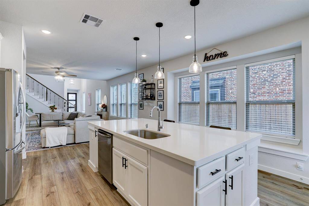 The kitchen features an oversized island, gas cooktop, and additional counter space.