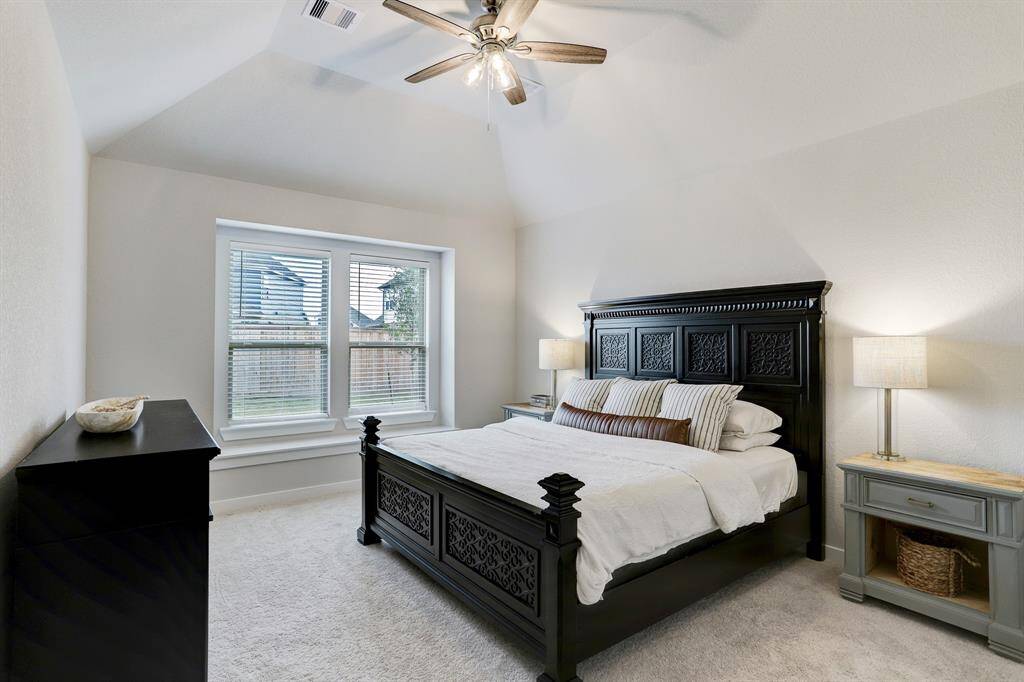A sizable 1st-floor primary suite features an ensuite bath, a vaulted ceiling, and window seat overlooking the large fenced-in back yard.
