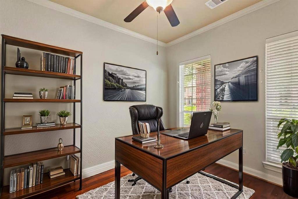 Virtually Staged: Nestled quietly in this immaculate home is the stunning home office! Featuring dark stained wood floors, crown molding details, windows with privacy blinds, and a ceiling fan.
