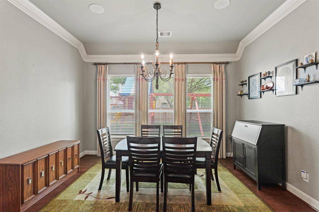 Elegant formal dining room with crown molding and chandelier.