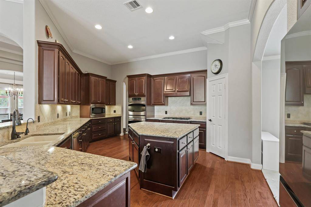 Chef’s kitchen features granite counters, a large center island, gas cooktop, and an abundance of cabinetry.