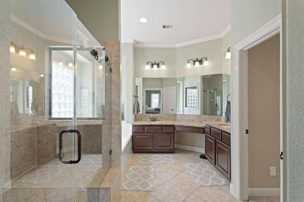 Primary bathroom with a spacious glass-enclosed shower.
