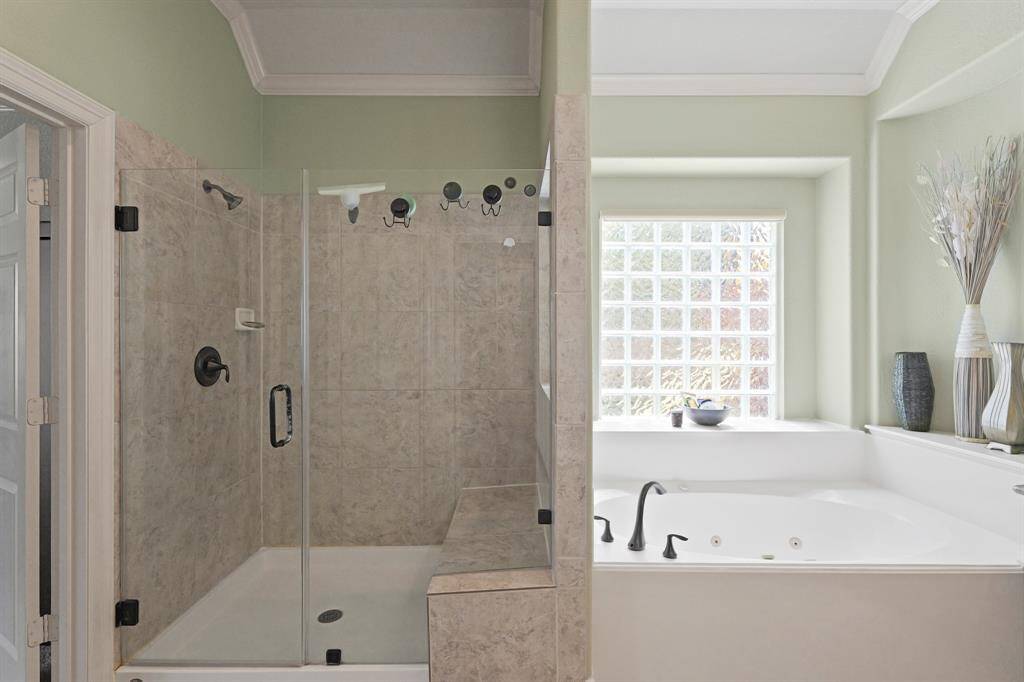 Relax and unwind in the oversized jetted tub, perfectly positioned beneath a large glass-block window for privacy and natural light.
