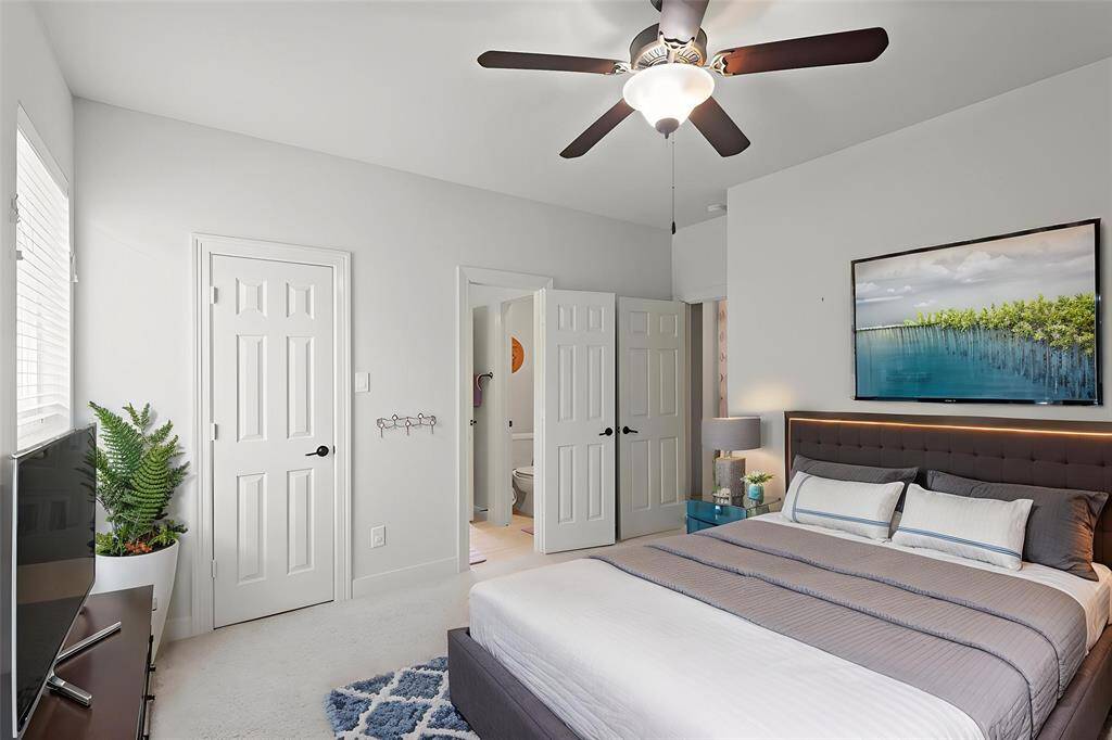 Virtually Staged: Secondary Bedroom featuring carpet floors, an en-suite bathroom, built-in closet, a ceiling fan, and windows with privacy blinds.