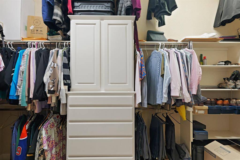 Custom-built storage and organization system in the spacious walk-in closet.