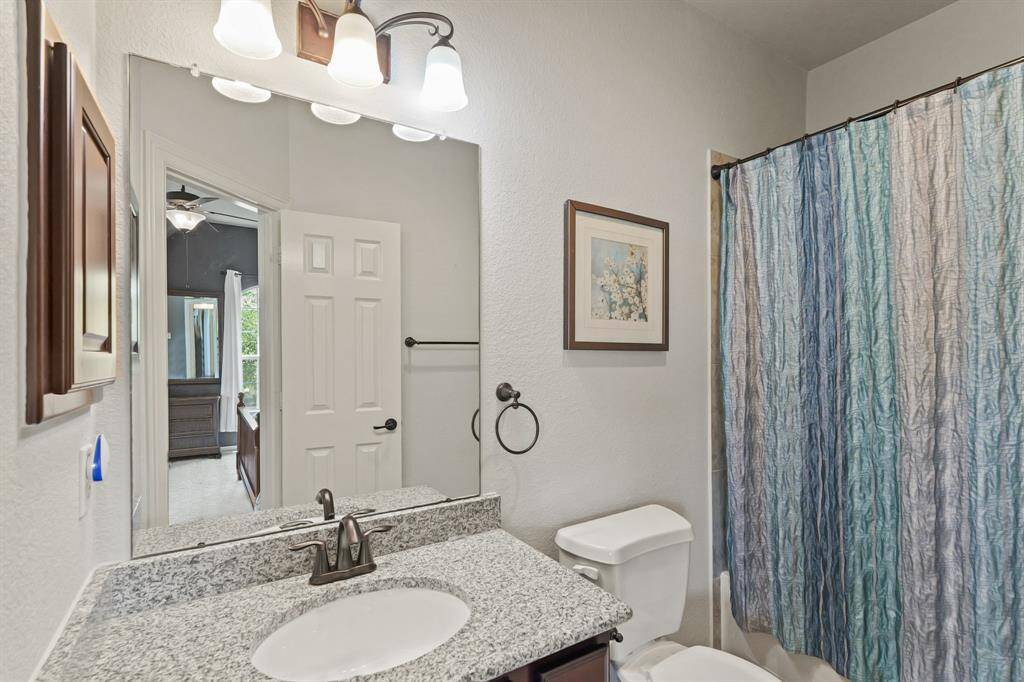 Full bathroom with granite vanity and tub/shower combo, perfect for guests or family use.