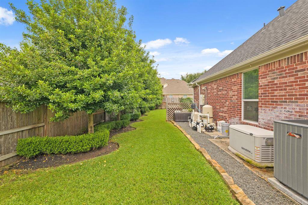 Side yard with mature trees and manicured hedges—perfect for pets or creating a private garden retreat.