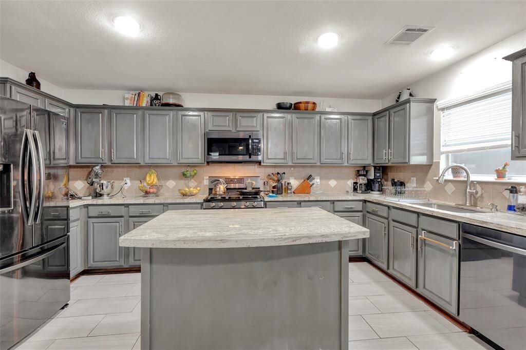 A full view of the kitchen from the island, showcasing its layout and design.