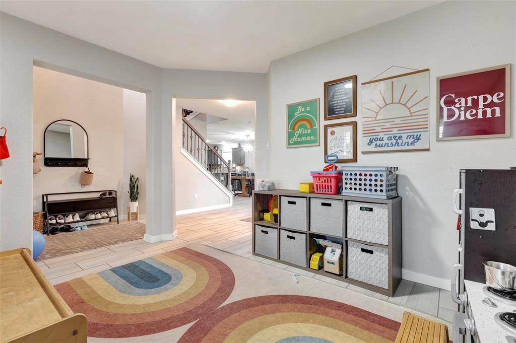 From this particular spot at the potential play room, you can see the the kitchen/dining area and the stairs leading the the second floor.
