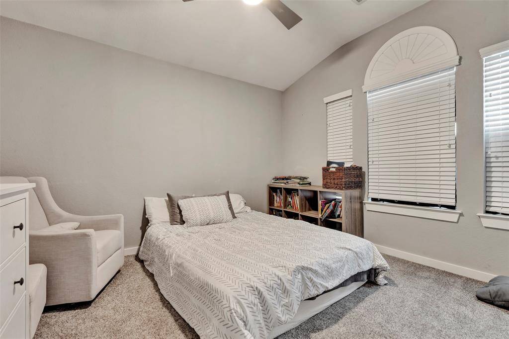 This secondary bedroom, located on the second floor and facing the front of the house like the primary bedroom, features a carpeted floor similar to the other two bedrooms.
