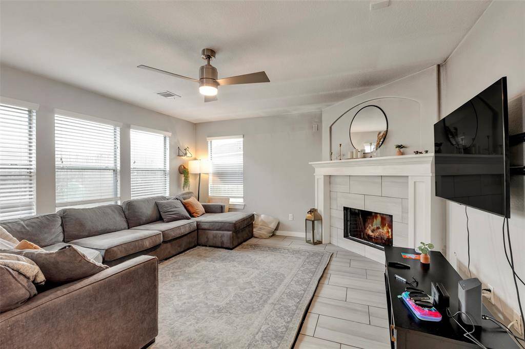 It has a bright living room with large windows and elegant tiled flooring.