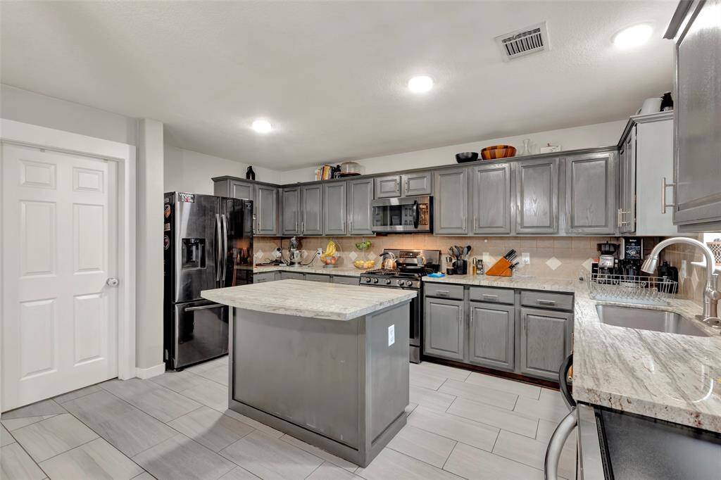 The kitchen features tiled flooring and sleek granite countertops.