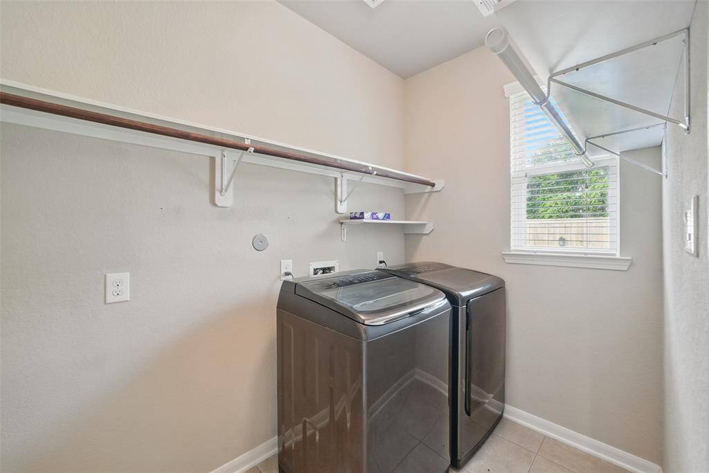 The laundry room is located at the back of the kitchen and has a sensor for the light and room for a second fridge.