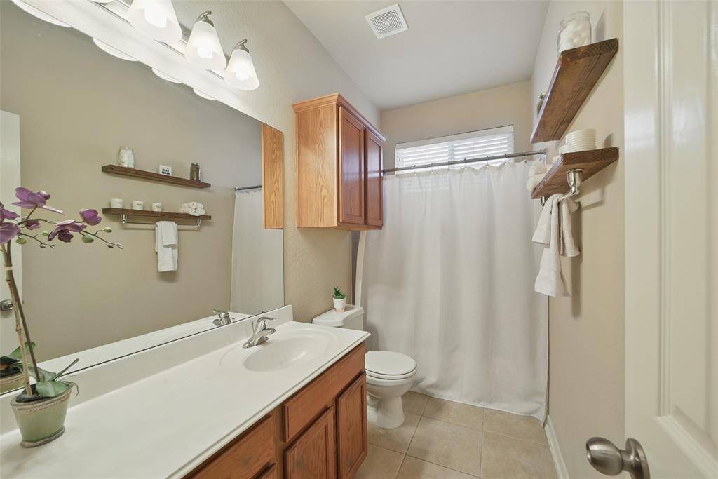 The guest bath features a shower/ tub combo, floating shelves and large countertop for getting ready.