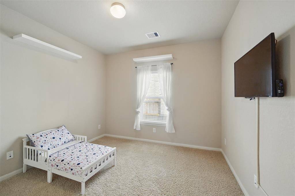 Guest bedroom 2 is also spacious with floating shelves and French doors on the closet.