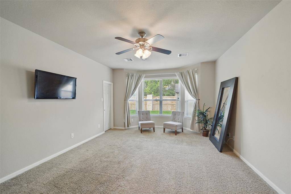 The owner's suite features a large bedroom, seating area, ceiling fan and walk-in closet.