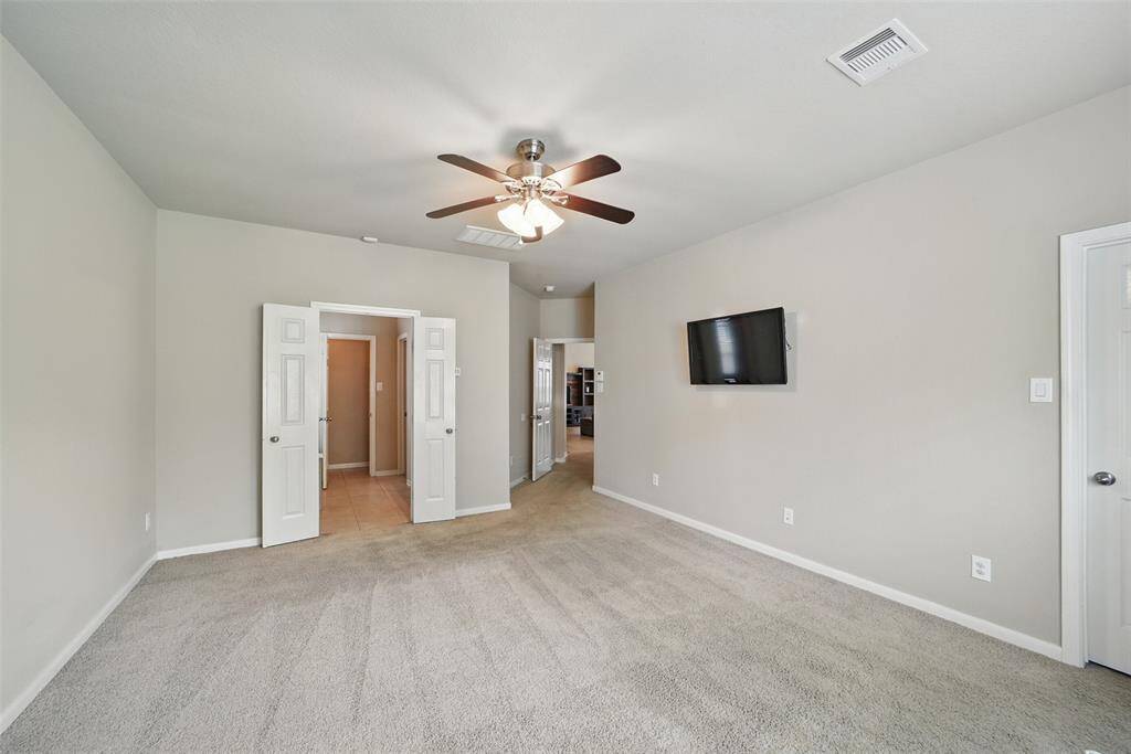 The view from the seating area shows the french doors leading to the primary bathroom.