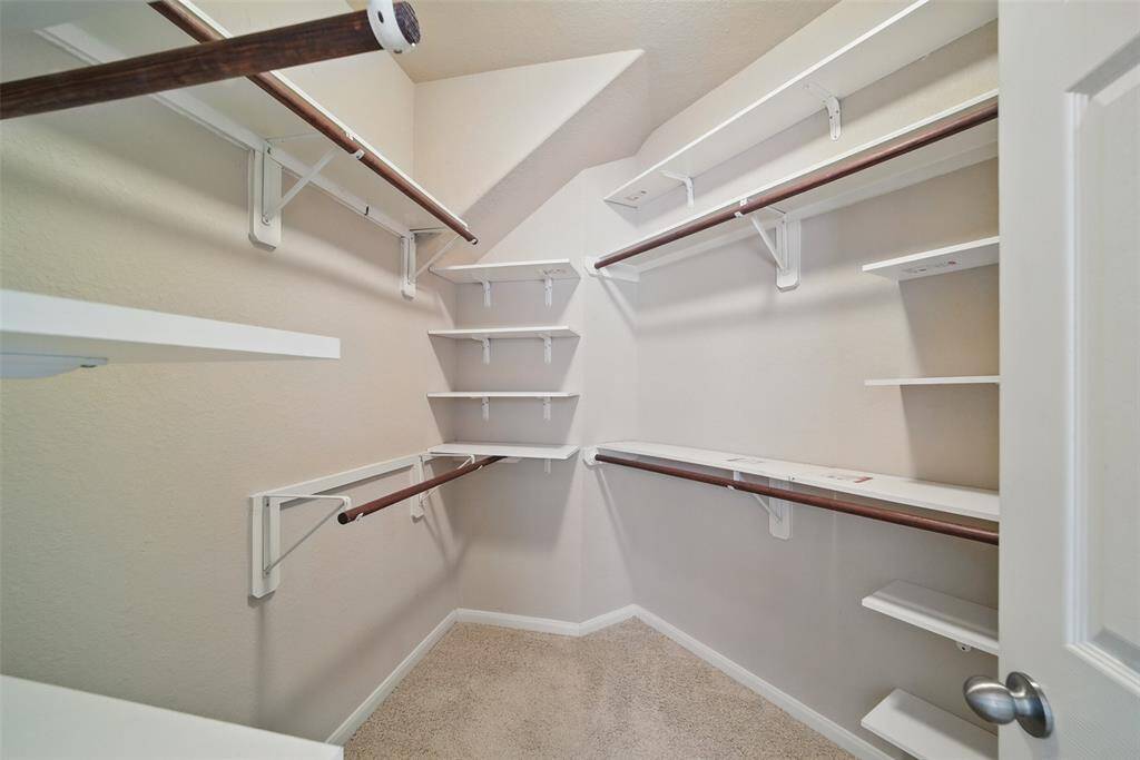 This larger walk-in closet has lots of shelving and clothes racks for all your accessories.