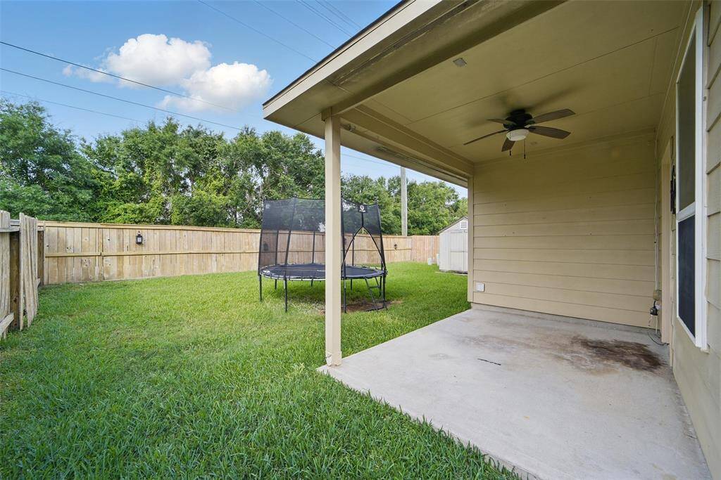 The backyard features a covered patio and large yard.