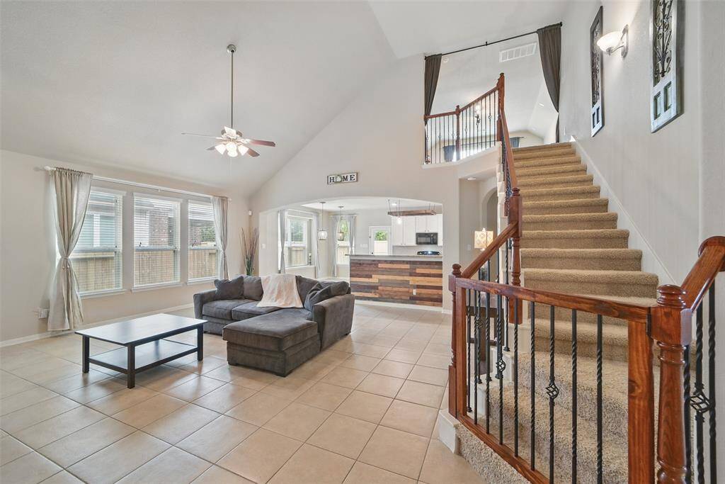 Lovely wood banister and wrought iron spindles lead upstairs to the game room.The family room features a wall of windows for lots of natural lighting.