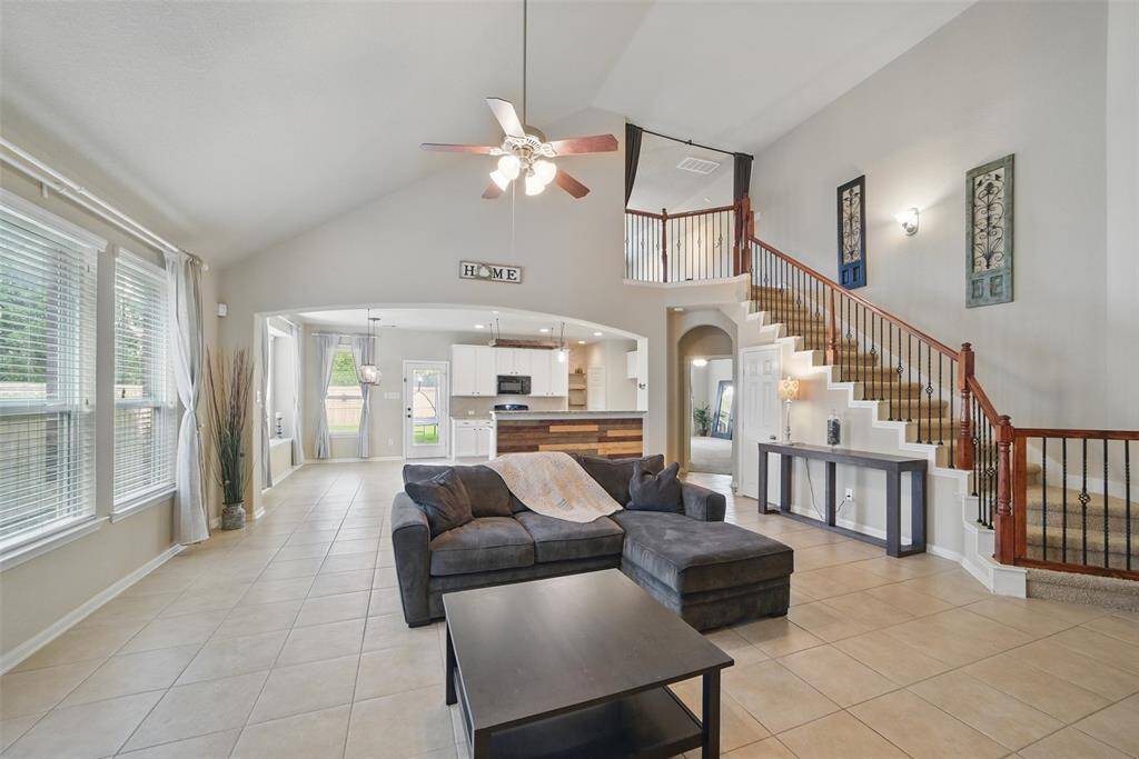 Another view shows how spacious the family room really is with window coverings, vaulted ceiling and decorative archways.