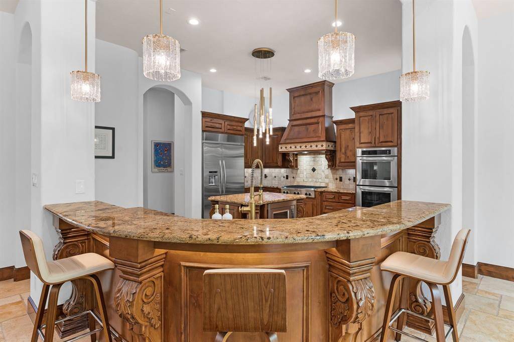 Thoughtfully designed, the kitchen boasts a walk-in pantry, tile backsplash, and granite countertops.