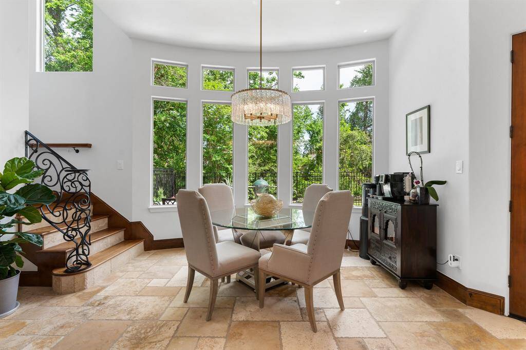 The breakfast room, framed by transom windows, offers a stunning view of the private landscape behind.