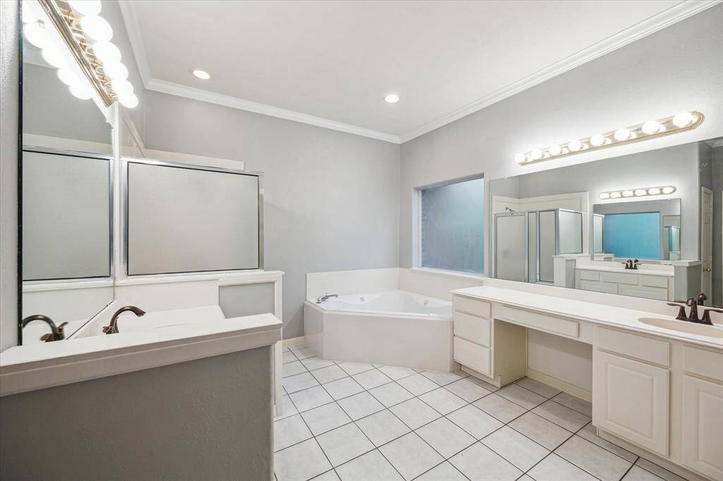 The primary ensuite offers a spa-like experience with double sinks, a dedicated vanity area, a relaxing soaking tub, and a separate walk-in shower.