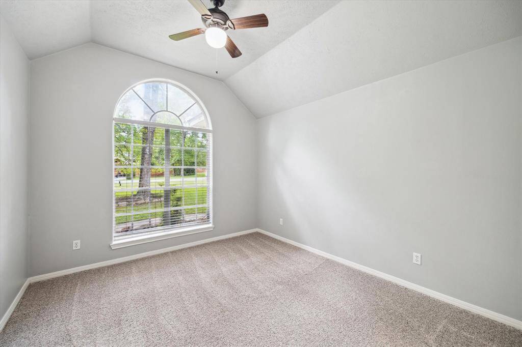 The final secondary bedroom offers a quiet retreat with front yard views and high ceilings.