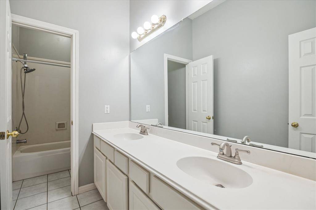 The shared split bathroom features double sinks, making busy mornings easier by allowing everyone space to get ready with minimal interruption.