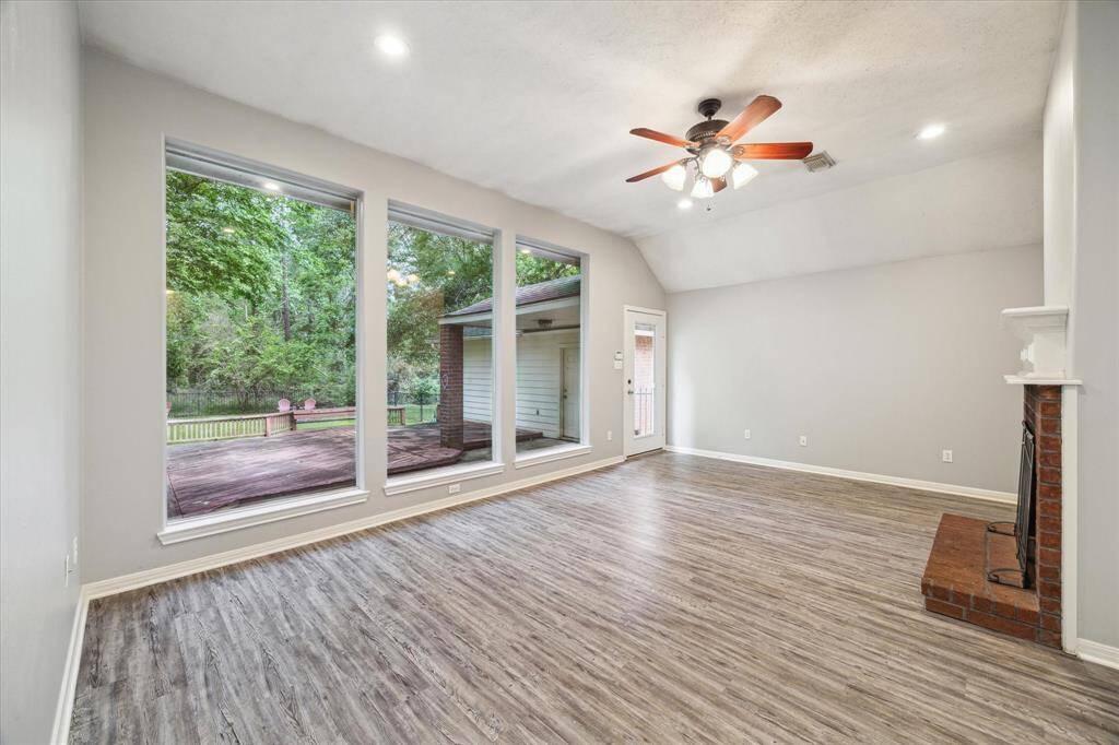 The living room is filled with natural light, thanks to large windows that offer serene views of the backyard.