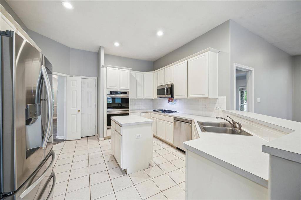 Another view of the kitchen highlights the double oven and gas cooktop—perfect for the home chef and ideal for entertaining.