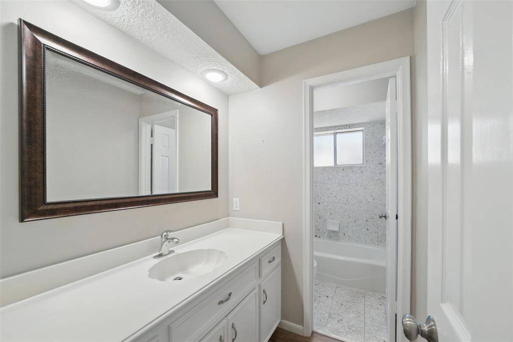 Secondary bath has lots of counter space and separate room for shower and toilet.