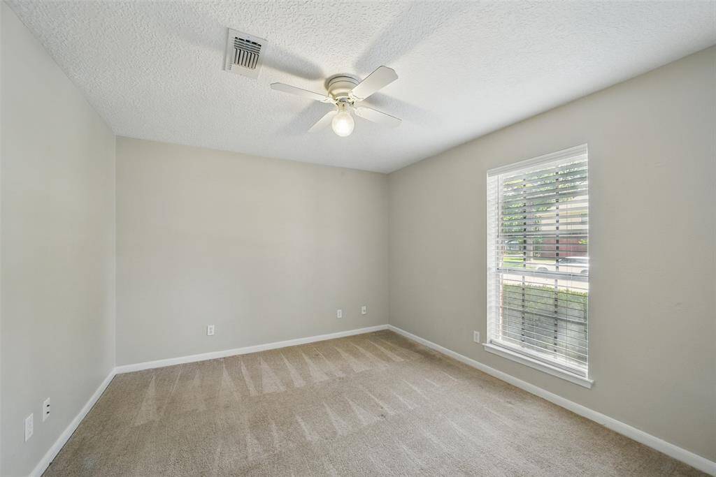 Secondary bedroom with plush carpet & ceiling fan.