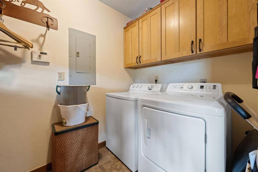 Laundry room features extra storage in upper cabinetry.