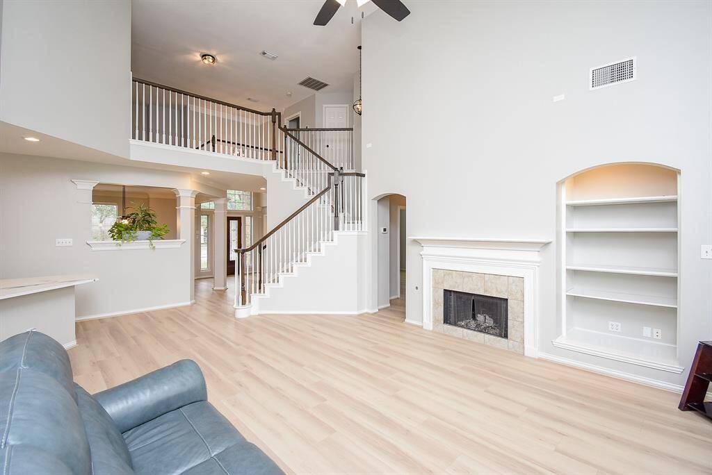 The open layout includes a stylish staircase leading to a second-floor landing, enhancing the airy feel of the space.