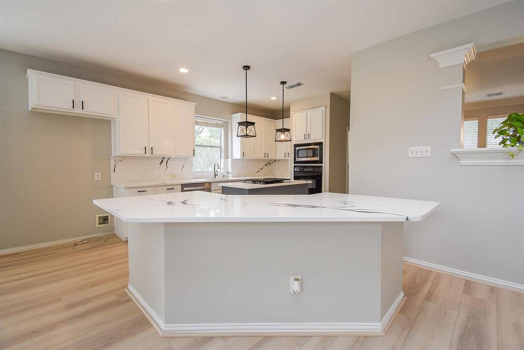 This modern kitchen features a large quartz countertop island.