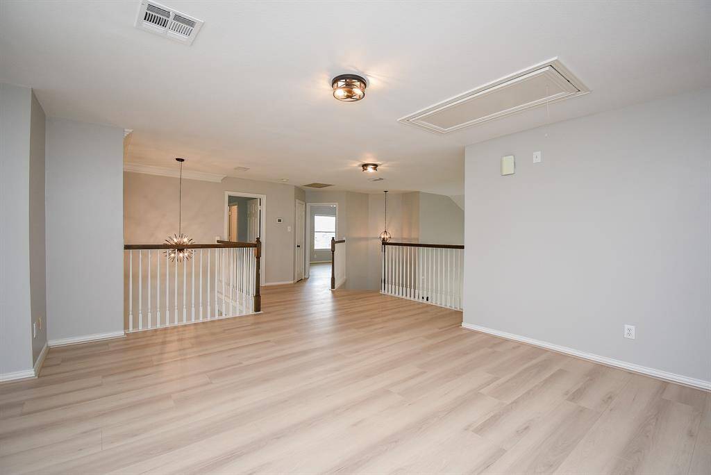The game room features modern lights and a stylish staircase, offering a bright, airy ambiance perfect for an entertainment space.