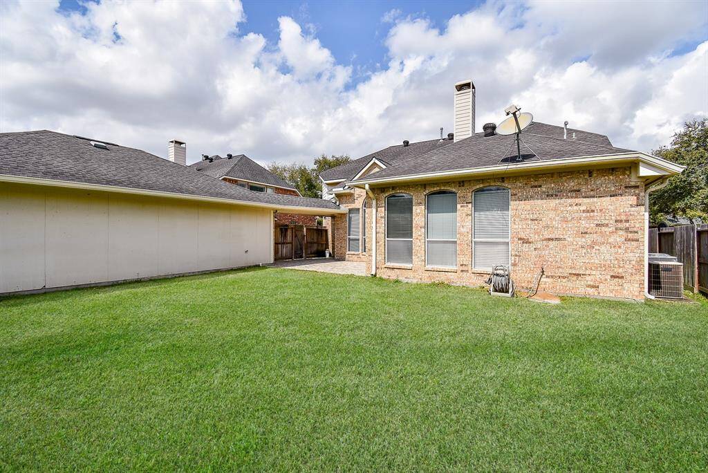 Another view of the well-maintained backyard with a lush green lawn.