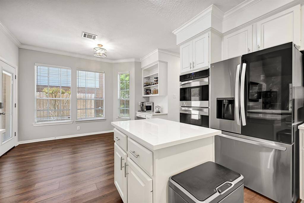 This kitchen features a streamlined fridge and a space-saving island for casual dining or prep