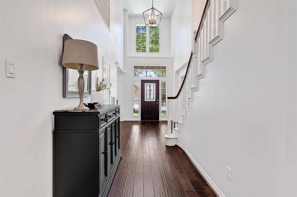 Elegant foyer where natural light pours in, beautifully showcasing warm hardwood flooring