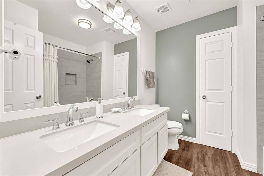 Bright and functional upper-level bath featuring a stylish double vanity for added convenience