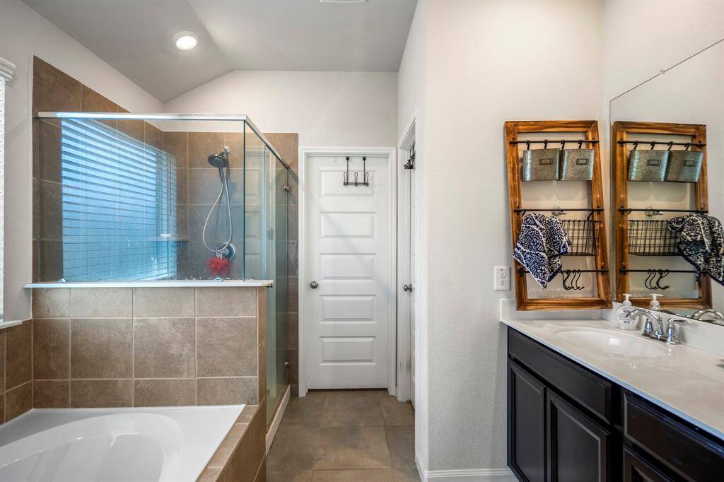 The primary bathroom has dual sinks, soaking tub, standalone shower and a generously sized closet.