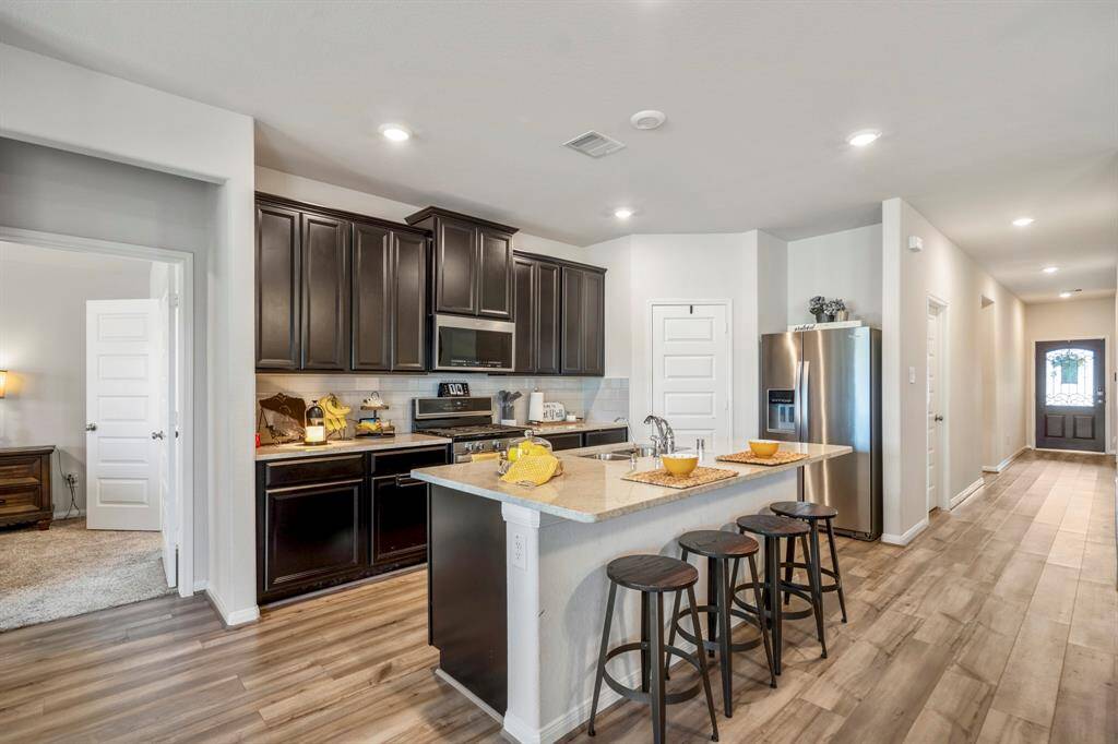 Your kitchen has been upgraded with granite counters, stainless steel appliances,a walk-in pantry, and open to the living areas.
