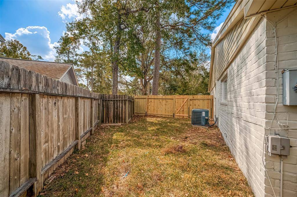 This is a spacious backyard with a wooden privacy fence and mature trees.